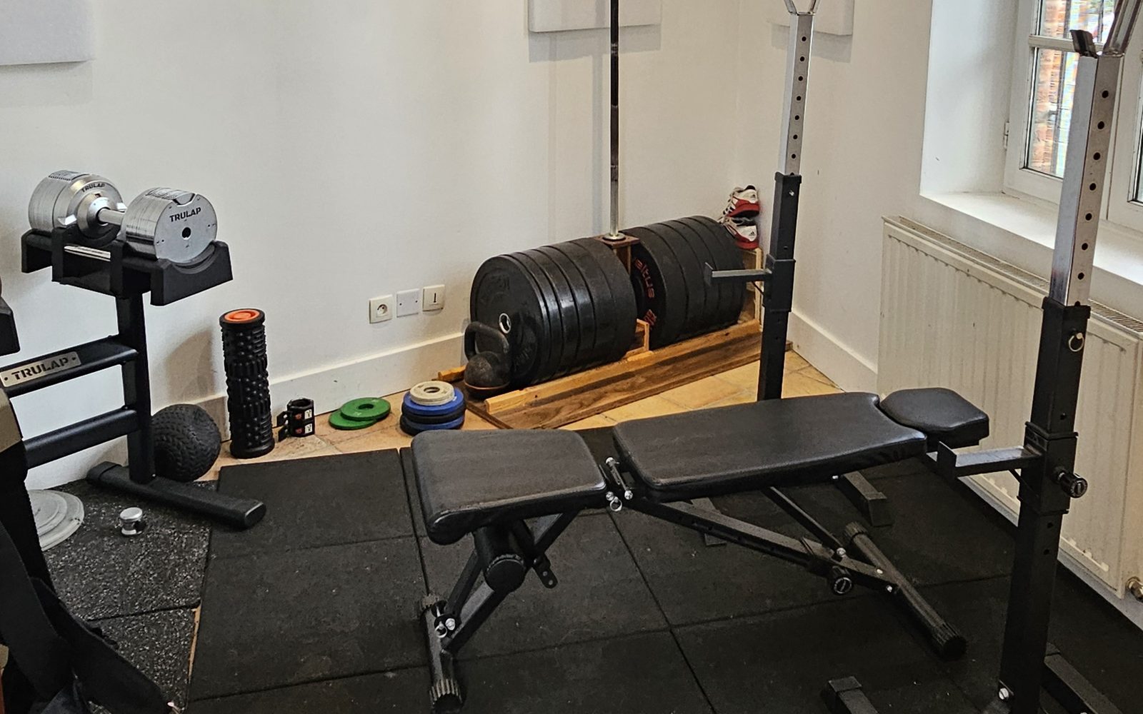 Le gym privatif de Thomas Lacarrière à Toulouse : banc, rack, barres et haltères
